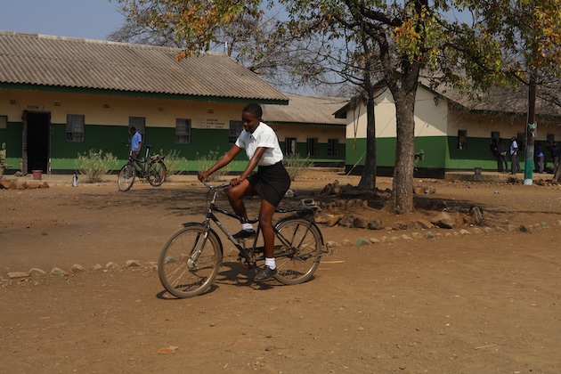 Faith Machavi pedalling a bicycle at Mwenje Dumisani Secondary Chiredzi in Zimbabwe. Credit Farai Shawn Matiashe IPS